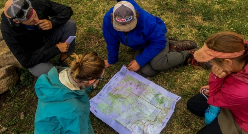 a group of outward bound gap year students examine a map